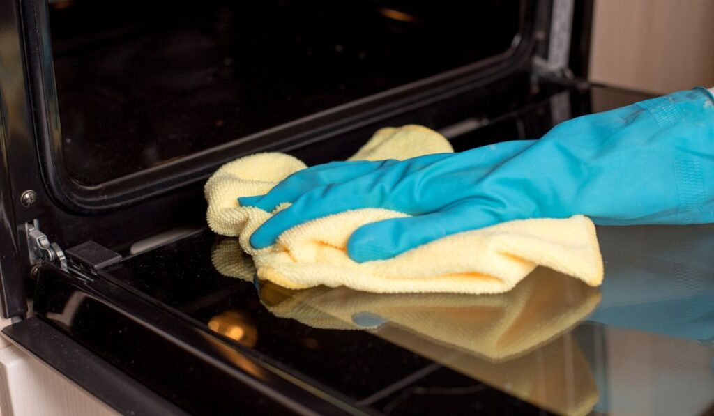 Cleaning open door of oven