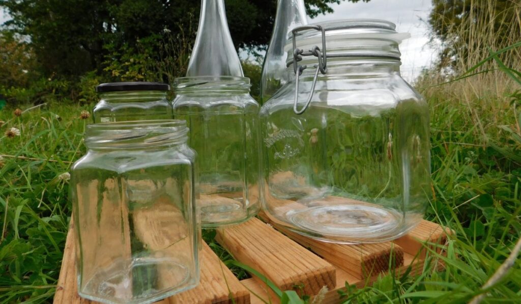 Recycled glass containers close-up in a meadow