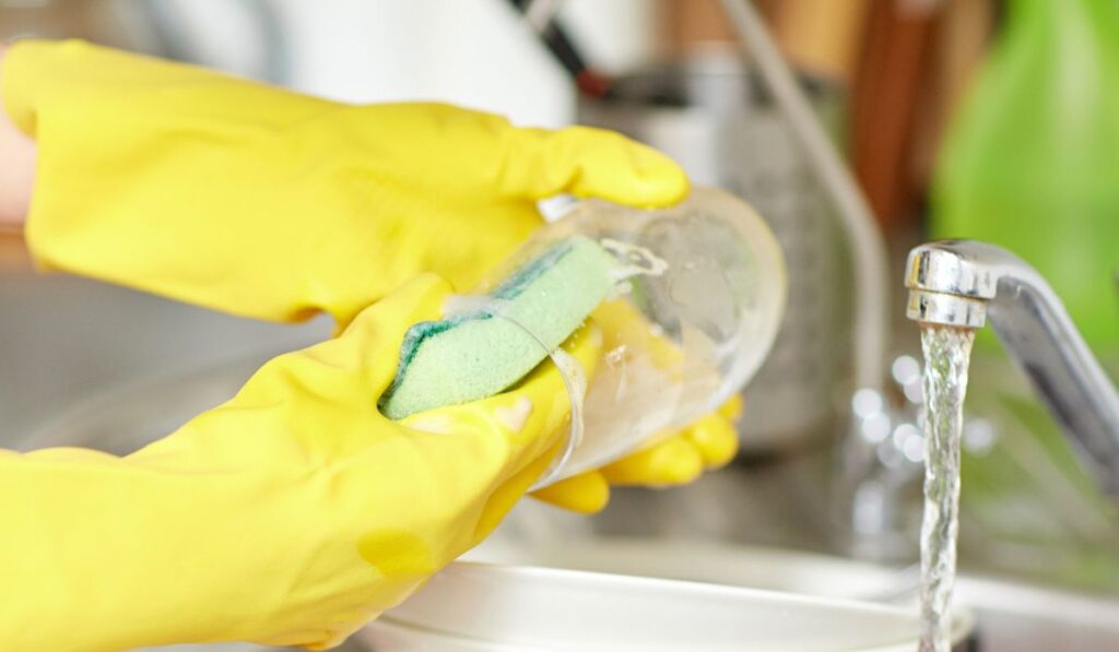 Close up of woman hands washing dishes in kitchen
