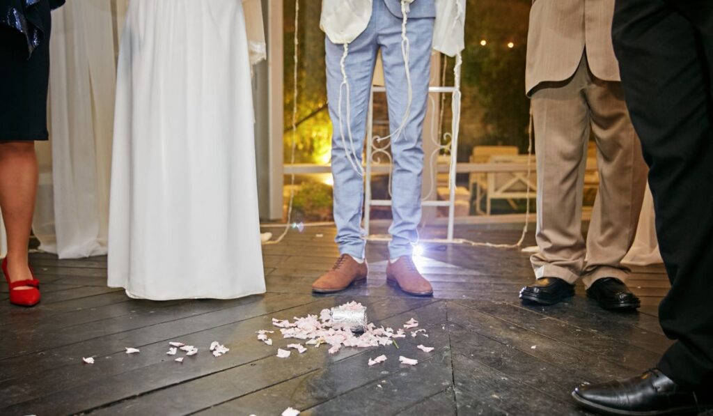 Groom at jewish wedding steps on a glass